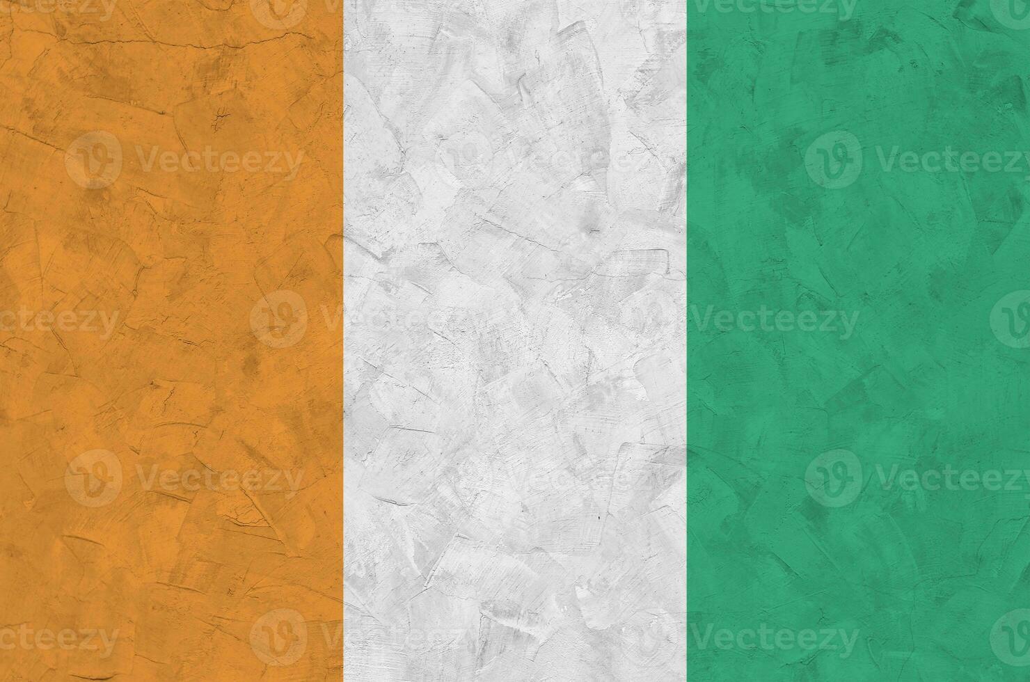 Ivory Coast flag depicted in bright paint colors on old relief plastering wall. Textured banner on rough background photo