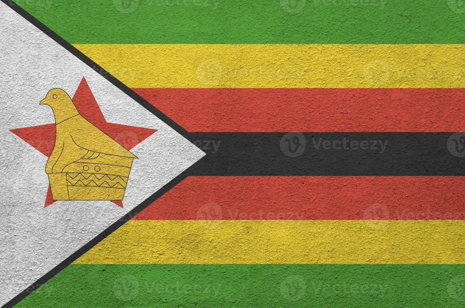 Zimbabwe flag depicted in bright paint colors on old relief plastering wall. Textured banner on rough background photo