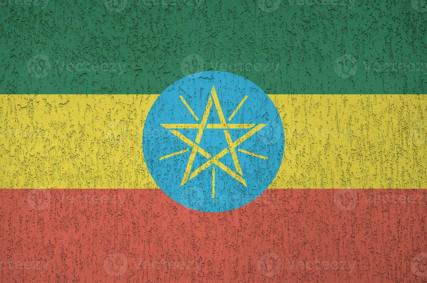 Ethiopia flag depicted in bright paint colors on old relief plastering wall. Textured banner on rough background photo