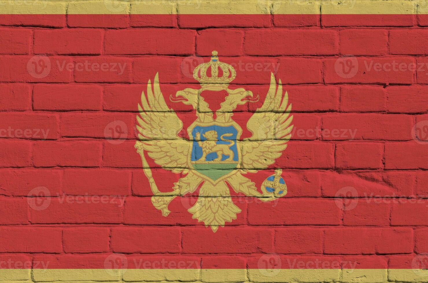 Montenegro flag depicted in paint colors on old brick wall. Textured banner on big brick wall masonry background photo