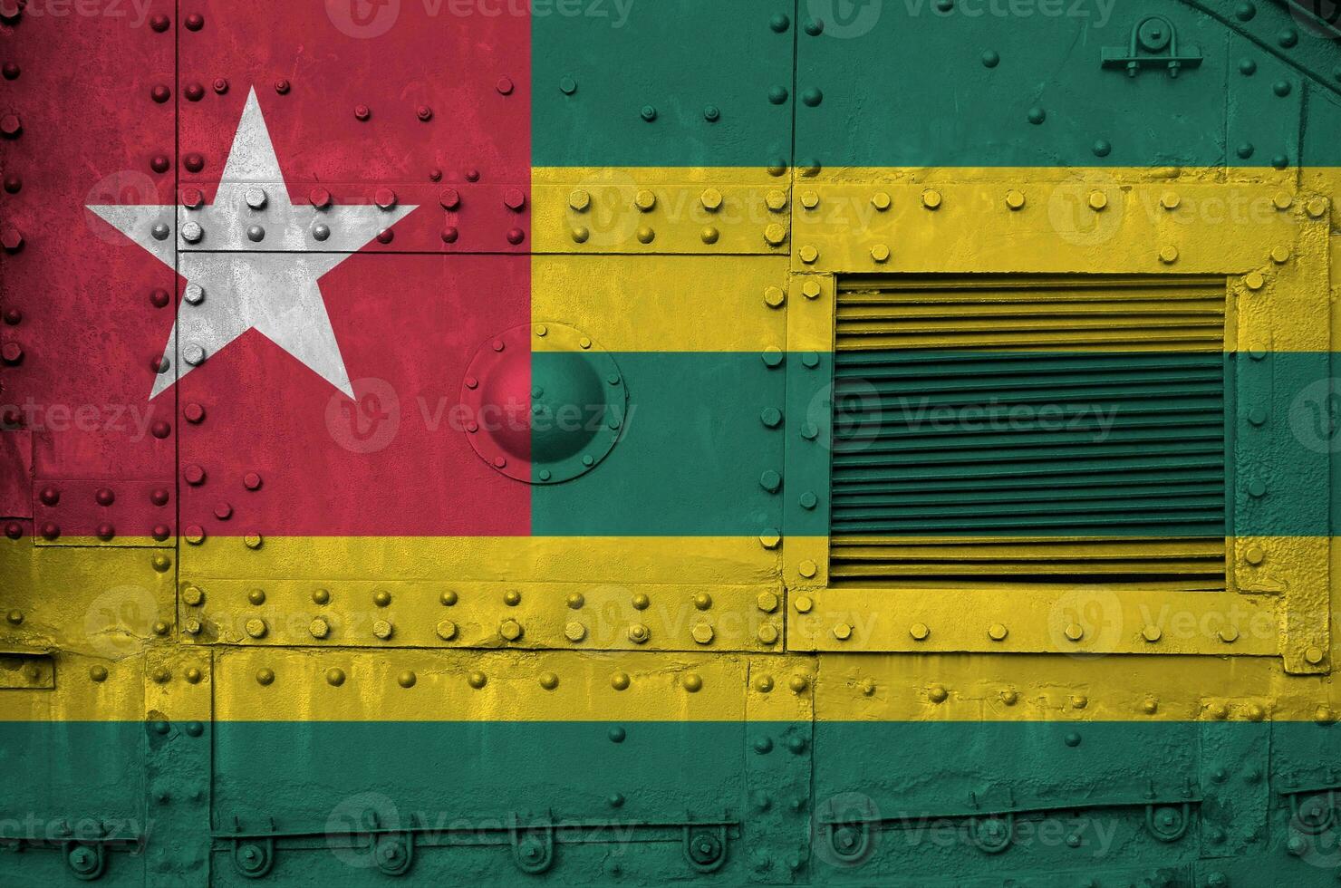 Togo flag depicted on side part of military armored tank closeup. Army forces conceptual background photo