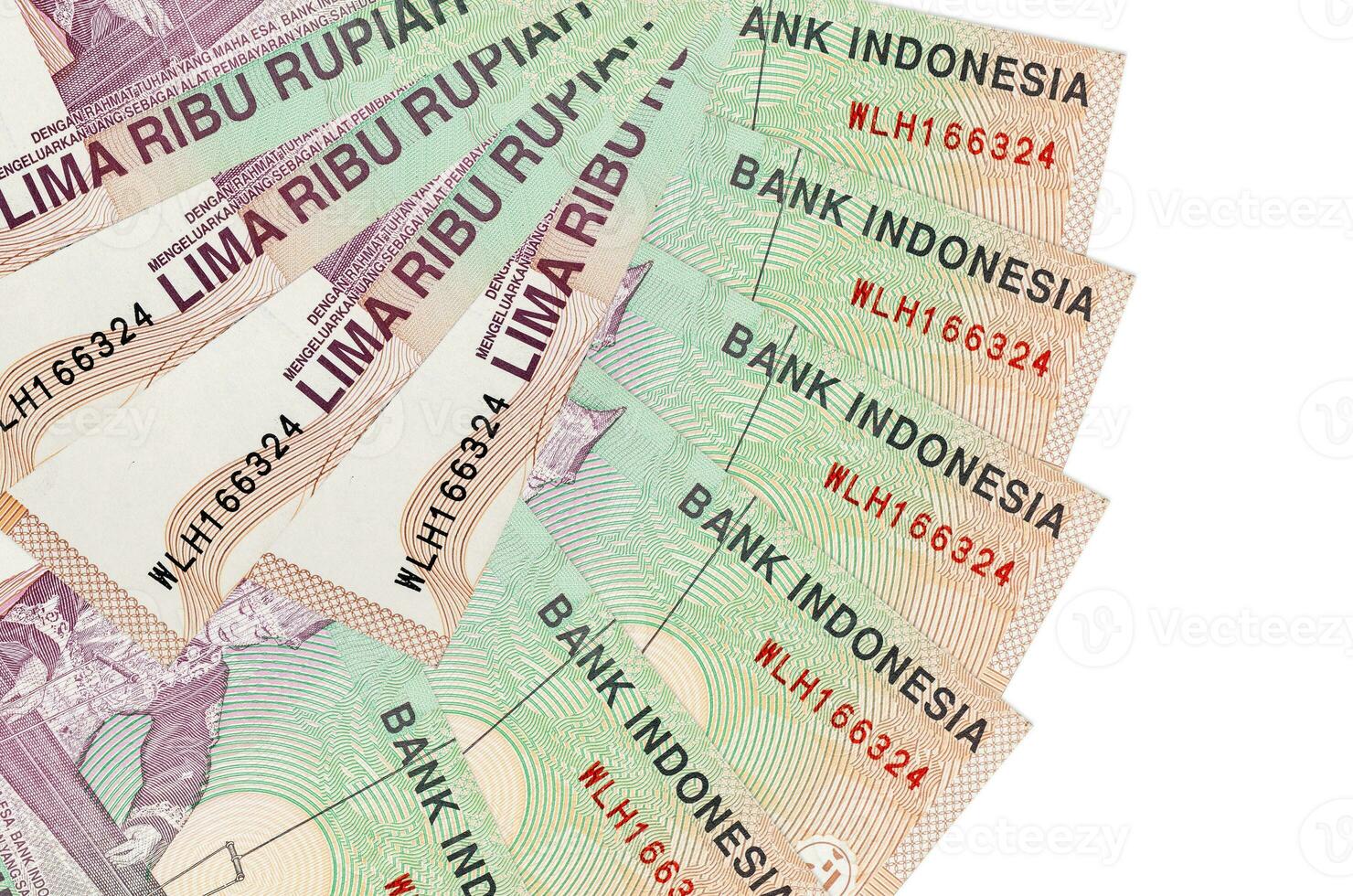 Los billetes de 5000 rupias indonesias se encuentran aislados en fondo blanco con espacio de copia apilado en forma de abanico de cerca foto