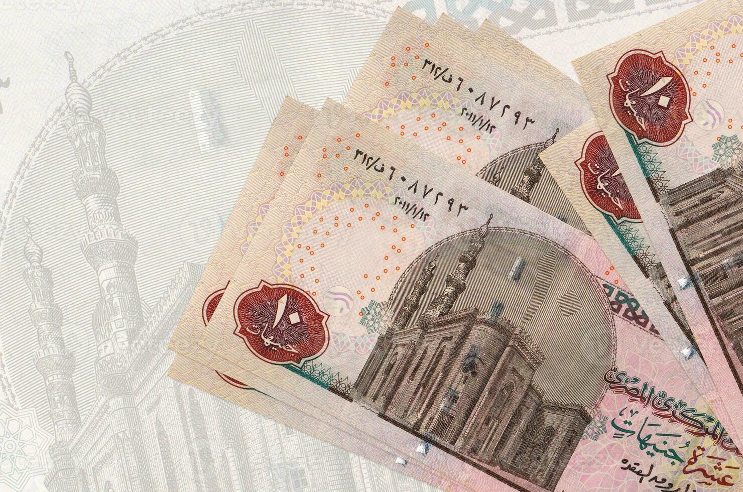 10 Egyptian pounds bills lies in stack on background of big semi-transparent banknote. Abstract presentation of national currency photo