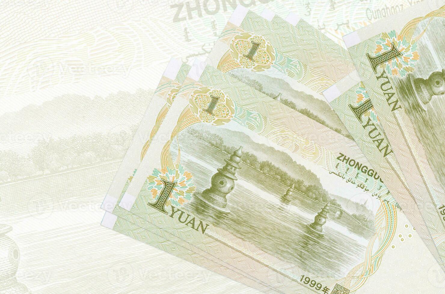 1 Chinese yuan bills lies in stack on background of big semi-transparent banknote. Abstract presentation of national currency photo