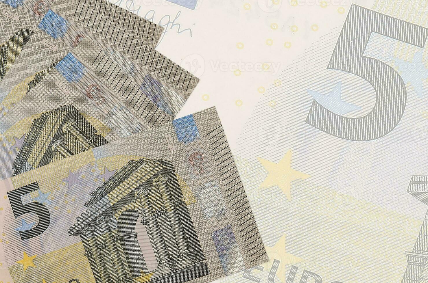5 euro bills lies in stack on background of big semi-transparent banknote. Abstract business background photo