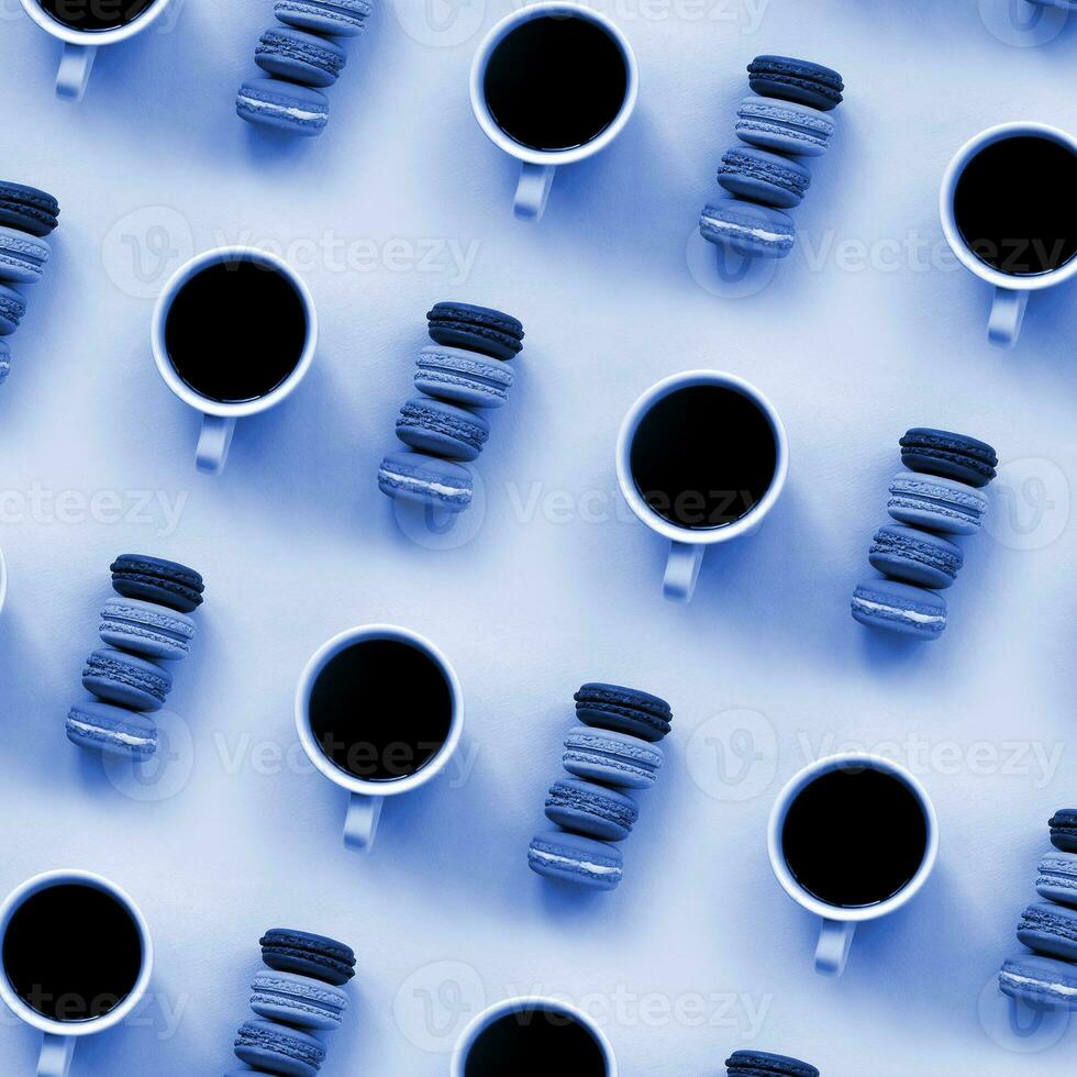A pattern of many colorful dessert cake macaroon and coffee cups on trendy phantom classic blue color background top view. Flat lay composition photo