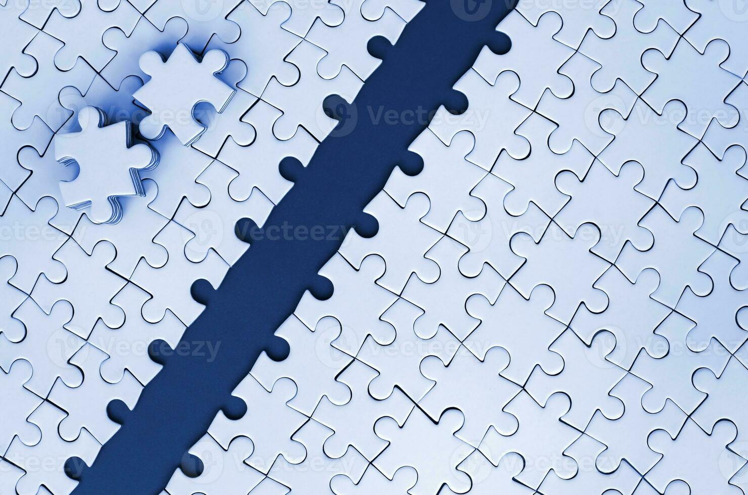 Path is laid on the platform of a white folded jigsaw puzzle. The missing elements of the puzzle are stacked nearby. Texture image with space for text. phantom classic blue color tone photo