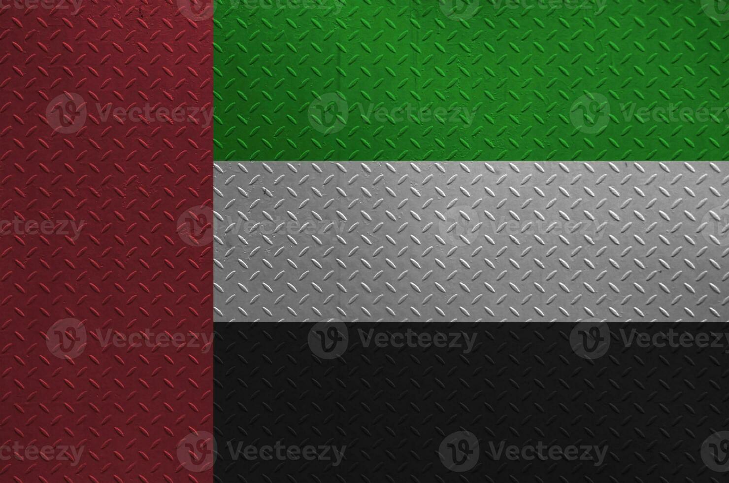 United Arab Emirates flag depicted in paint colors on old brushed metal plate or wall closeup. Textured banner on rough background photo