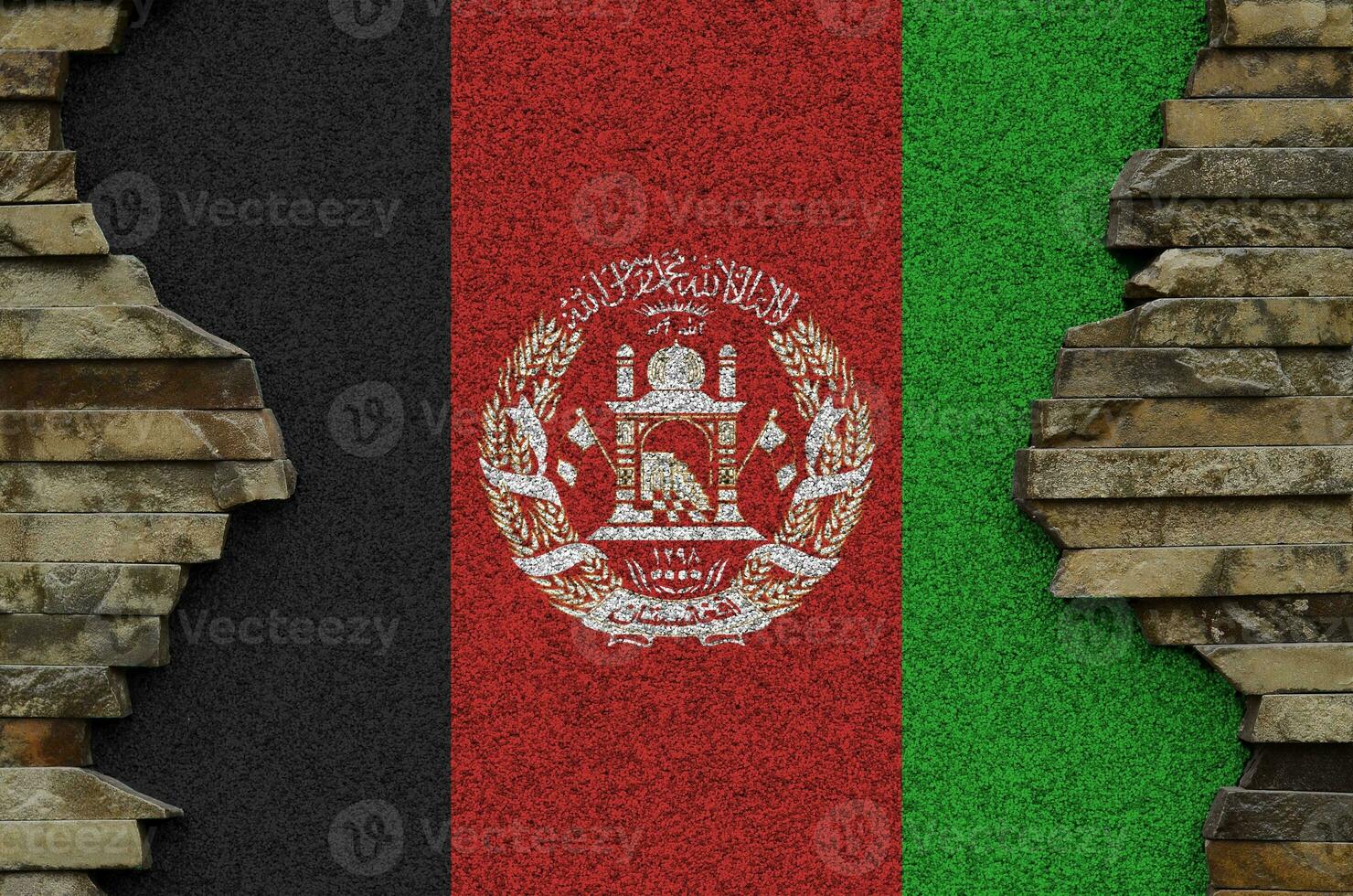 Afghanistan flag depicted in paint colors on old stone wall closeup. Textured banner on rock wall background photo