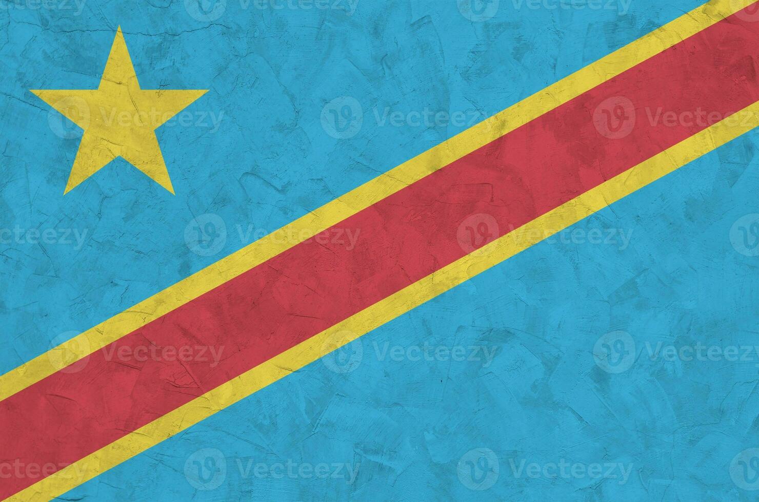 Democratic Republic of the Congo flag depicted in bright paint colors on old relief plastering wall. Textured banner on rough background photo