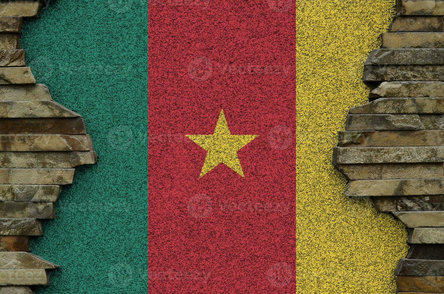 Cameroon flag depicted in paint colors on old stone wall closeup. Textured banner on rock wall background photo