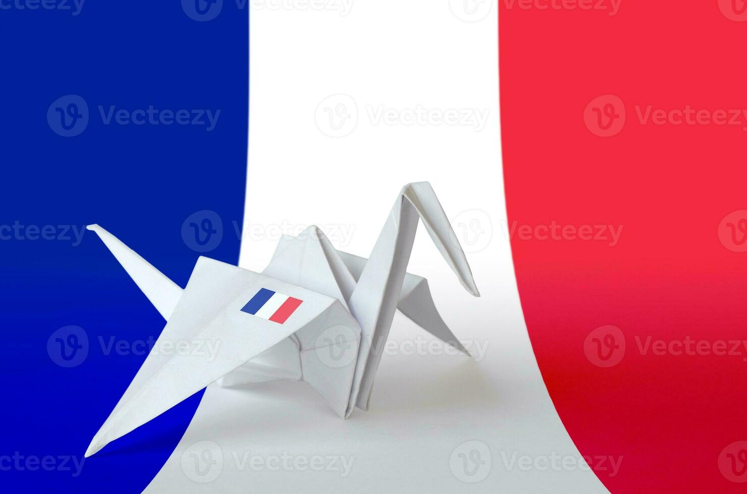 France flag depicted on paper origami crane wing. Handmade arts concept photo