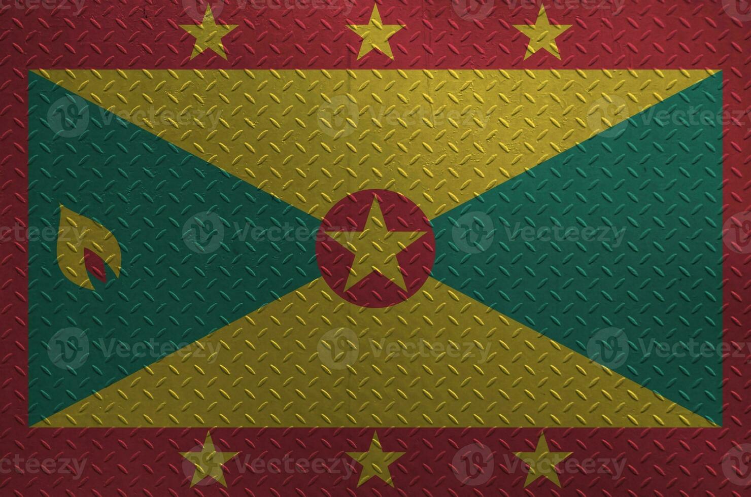 Grenada flag depicted in paint colors on old brushed metal plate or wall closeup. Textured banner on rough background photo