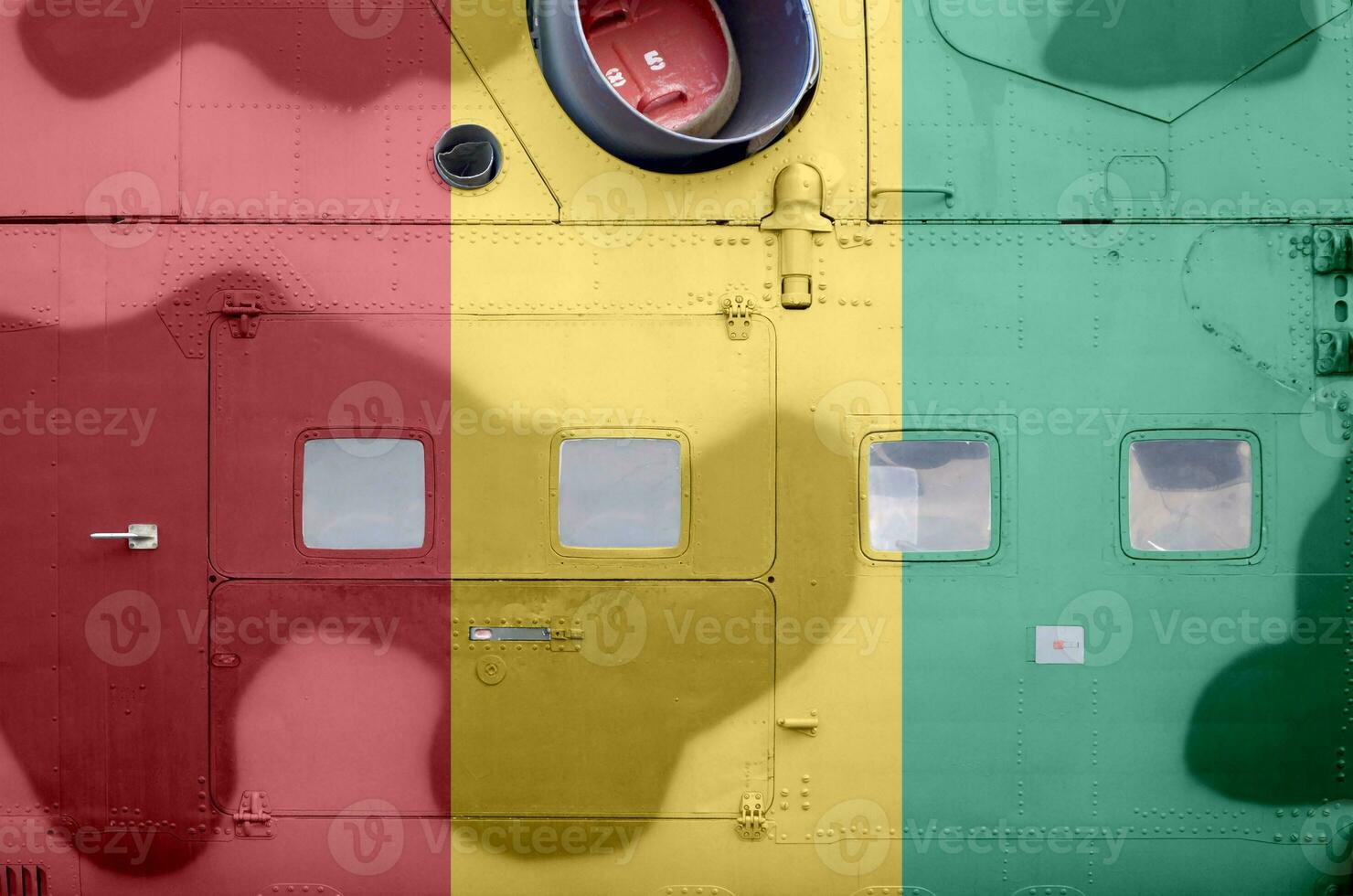 Guinea flag depicted on side part of military armored helicopter closeup. Army forces aircraft conceptual background photo