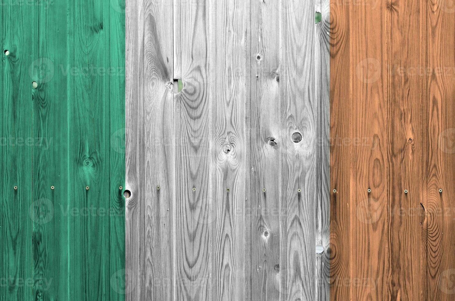 Ireland flag depicted in bright paint colors on old wooden wall. Textured banner on rough background photo