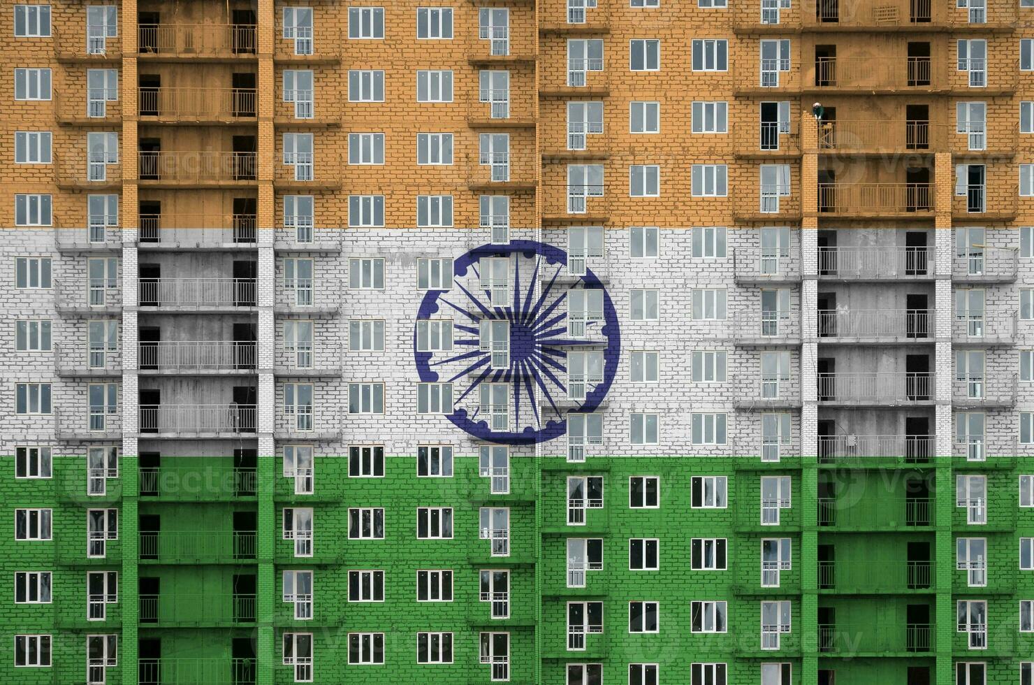 India flag depicted in paint colors on multi-storey residental building under construction. Textured banner on brick wall background photo