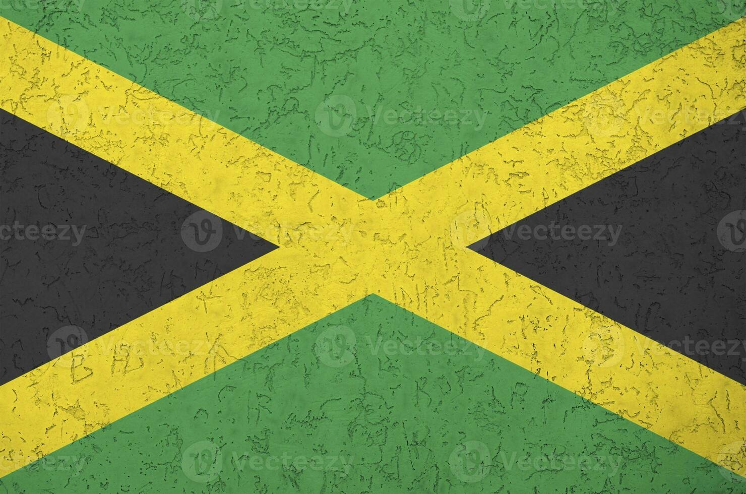 Jamaica flag depicted in bright paint colors on old relief plastering wall. Textured banner on rough background photo