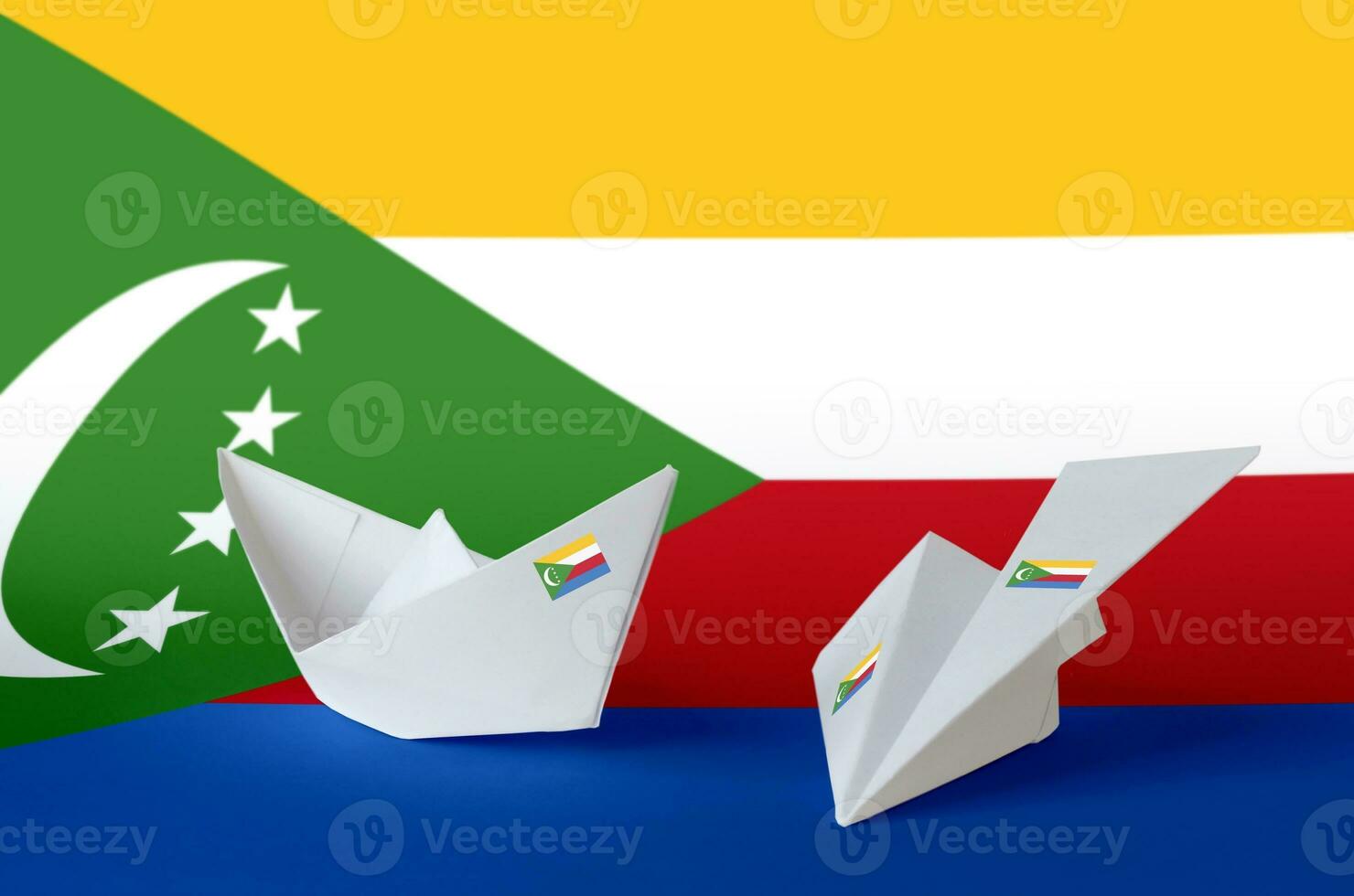 Comoros flag depicted on paper origami airplane and boat. Handmade arts concept photo
