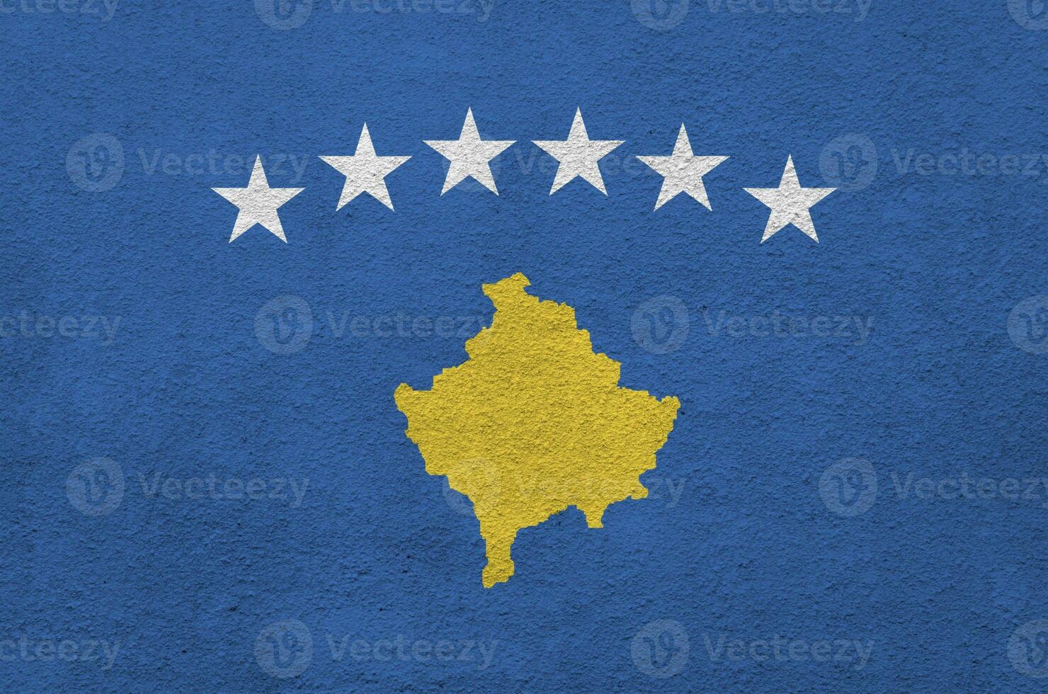 Kosovo flag depicted in bright paint colors on old relief plastering wall. Textured banner on rough background photo