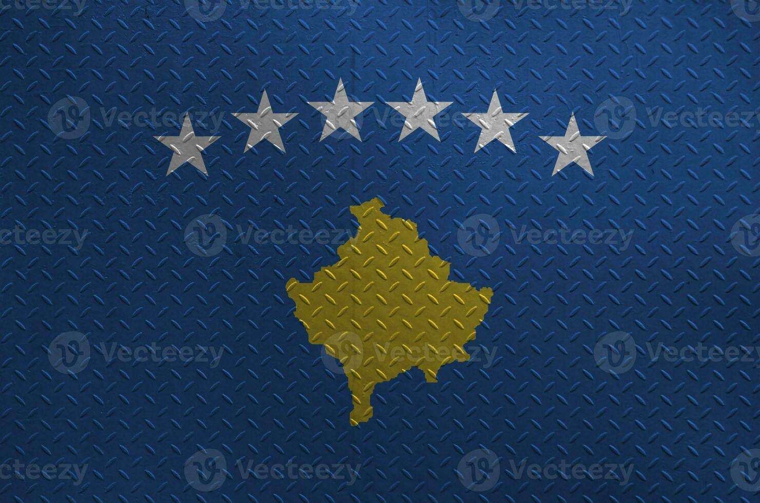 Kosovo flag depicted in paint colors on old brushed metal plate or wall closeup. Textured banner on rough background photo