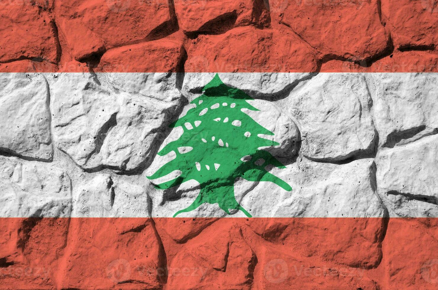 Lebanon flag depicted in paint colors on old stone wall closeup. Textured banner on rock wall background photo