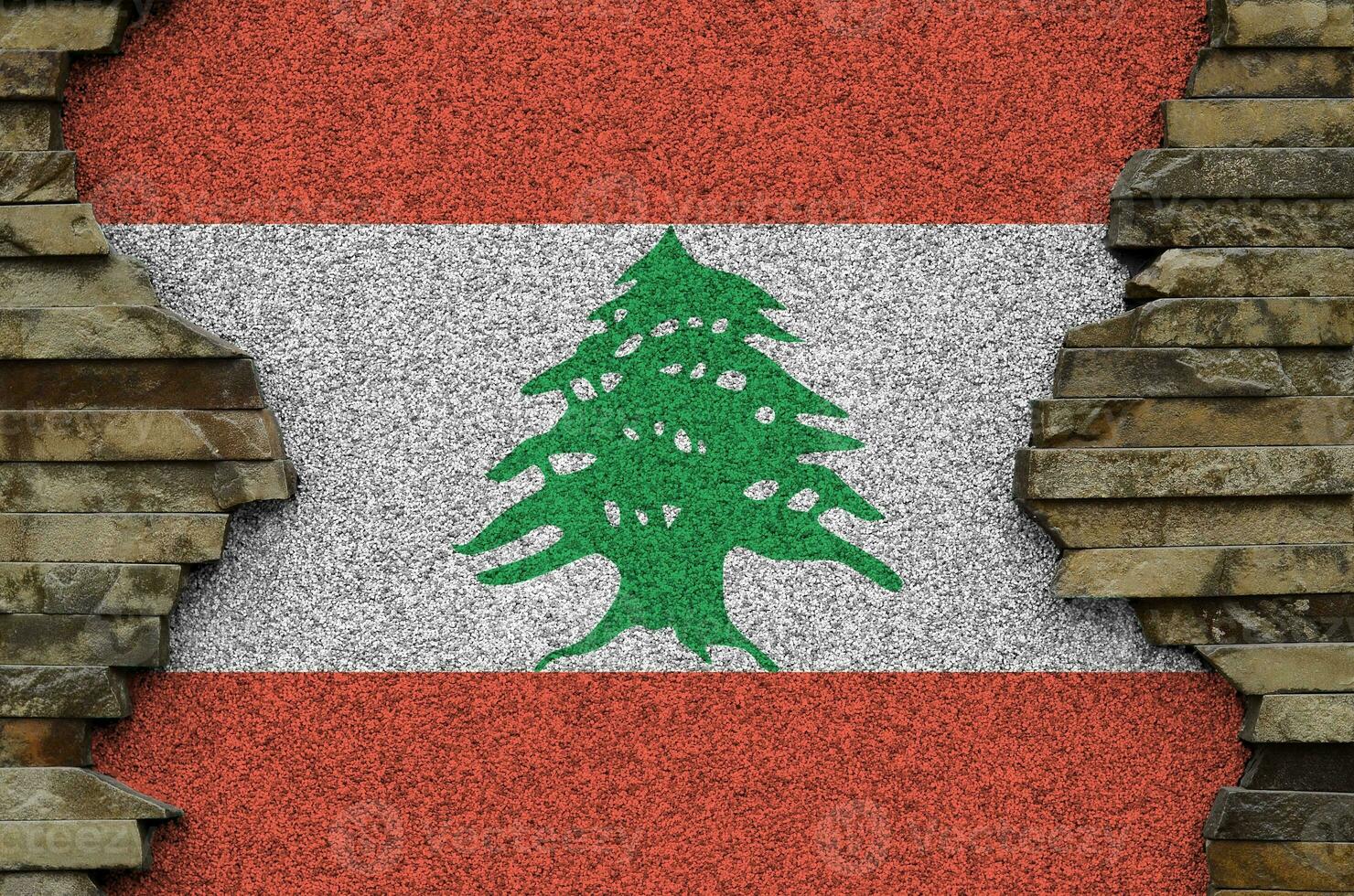 Lebanon flag depicted in paint colors on old stone wall closeup. Textured banner on rock wall background photo