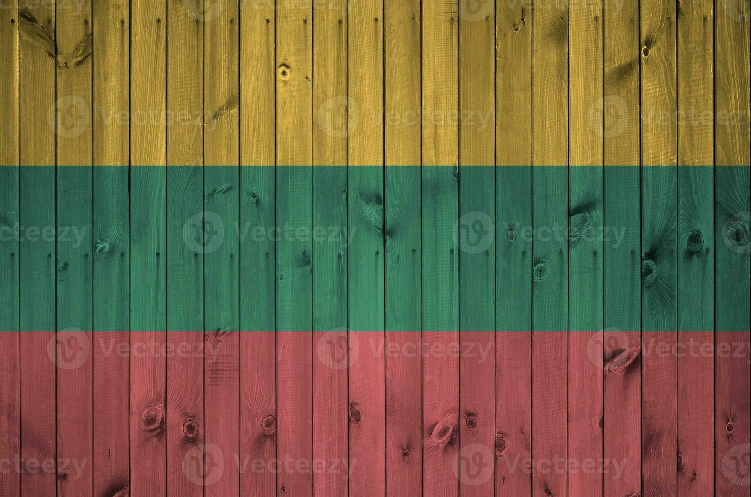 Lithuania flag depicted in bright paint colors on old wooden wall. Textured banner on rough background photo