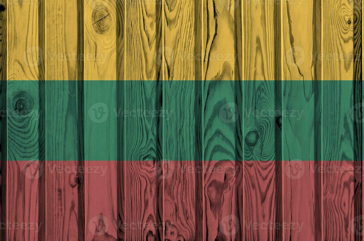 Lithuania flag depicted in bright paint colors on old wooden wall. Textured banner on rough background photo