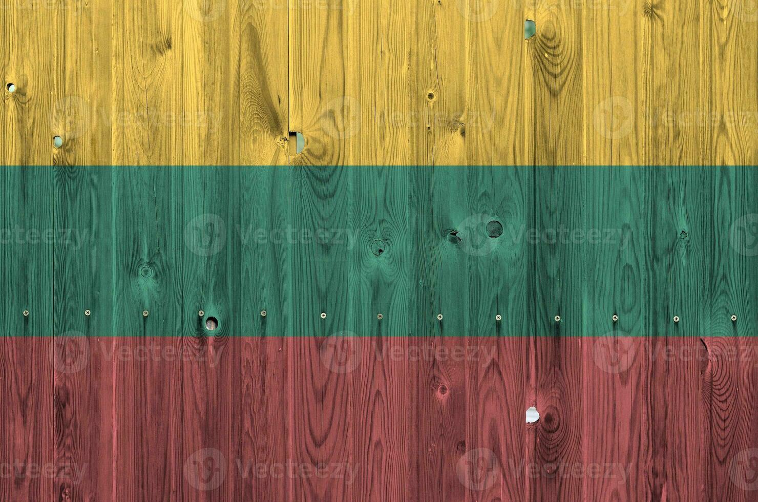 Lithuania flag depicted in bright paint colors on old wooden wall. Textured banner on rough background photo