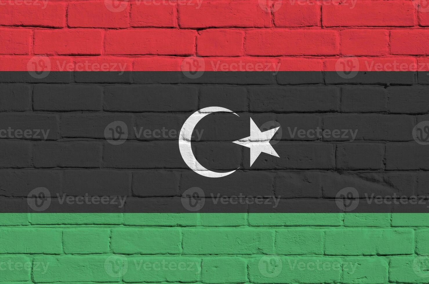 Libya flag depicted in paint colors on old brick wall. Textured banner on big brick wall masonry background photo