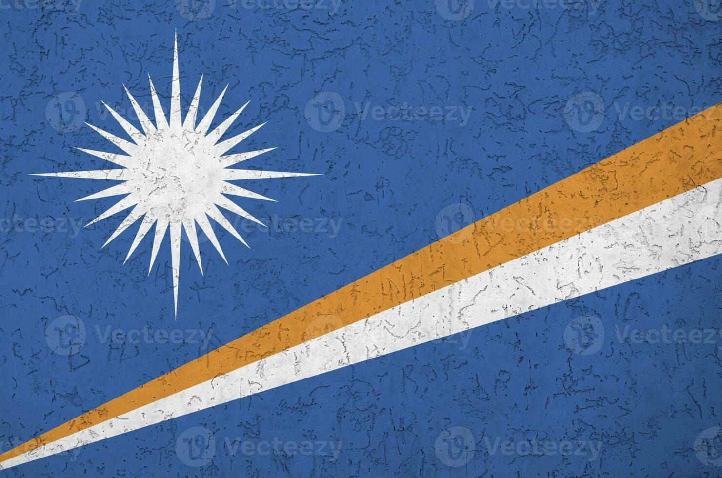 Marshall Islands flag depicted in bright paint colors on old relief plastering wall. Textured banner on rough background photo