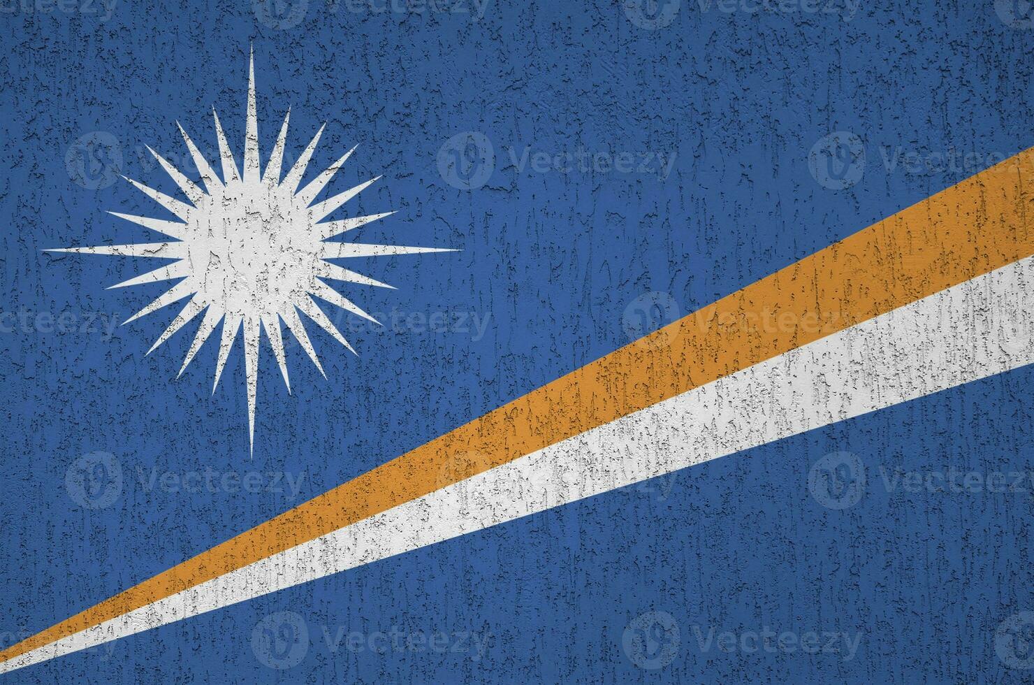 Marshall Islands flag depicted in bright paint colors on old relief plastering wall. Textured banner on rough background photo