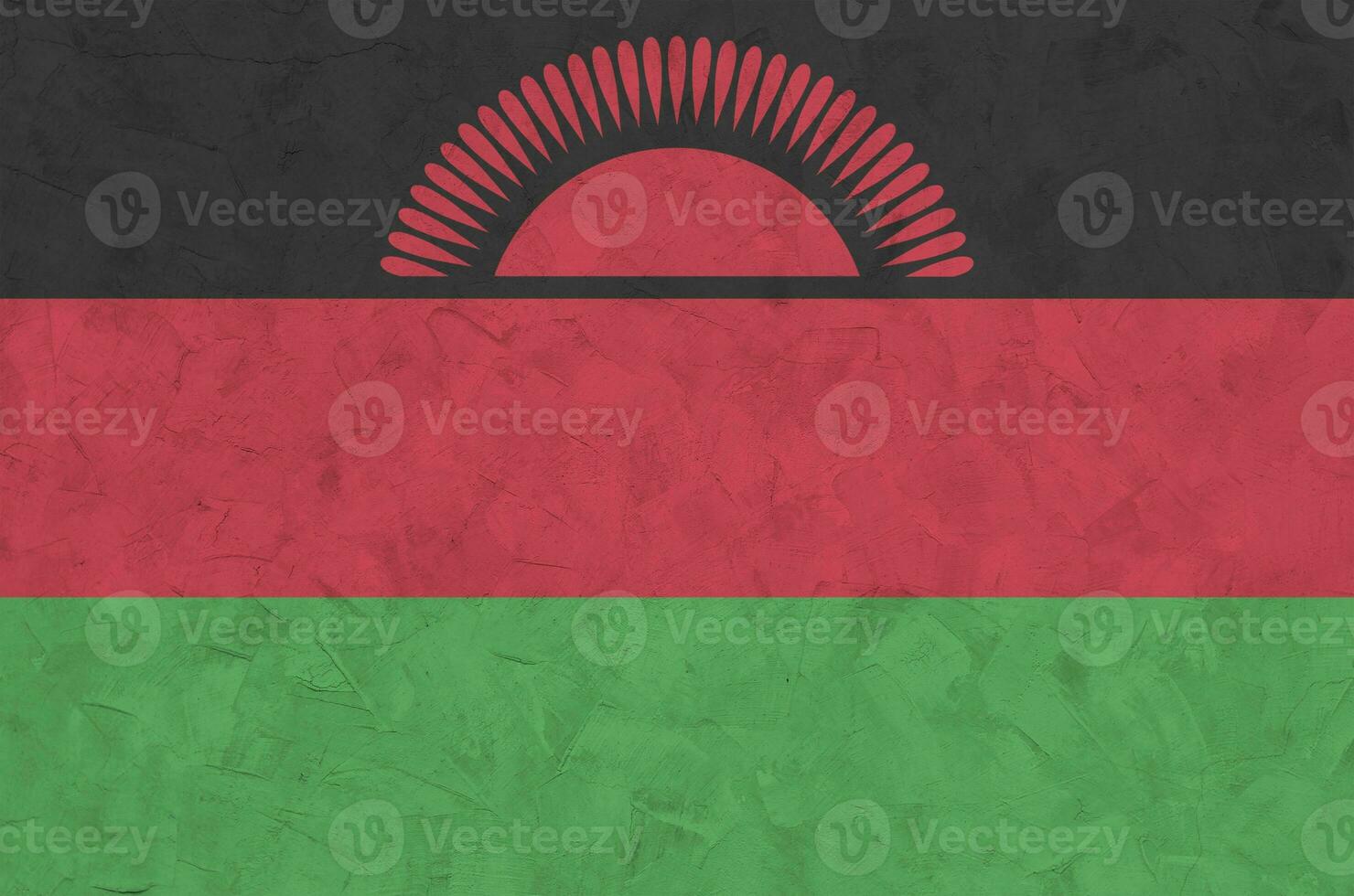 Malawi flag depicted in bright paint colors on old relief plastering wall. Textured banner on rough background photo