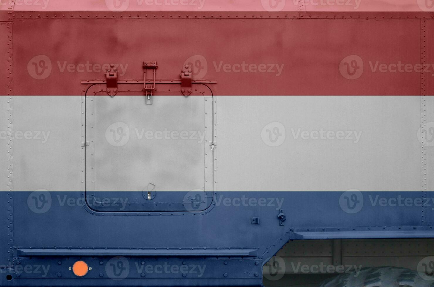 Netherlands flag depicted on side part of military armored truck closeup. Army forces conceptual background photo