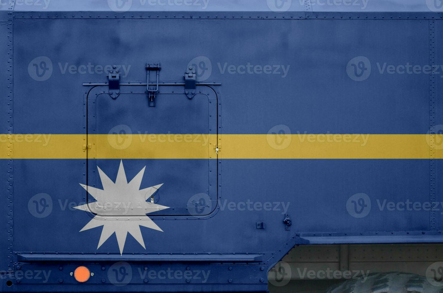 Nauru flag depicted on side part of military armored truck closeup. Army forces conceptual background photo