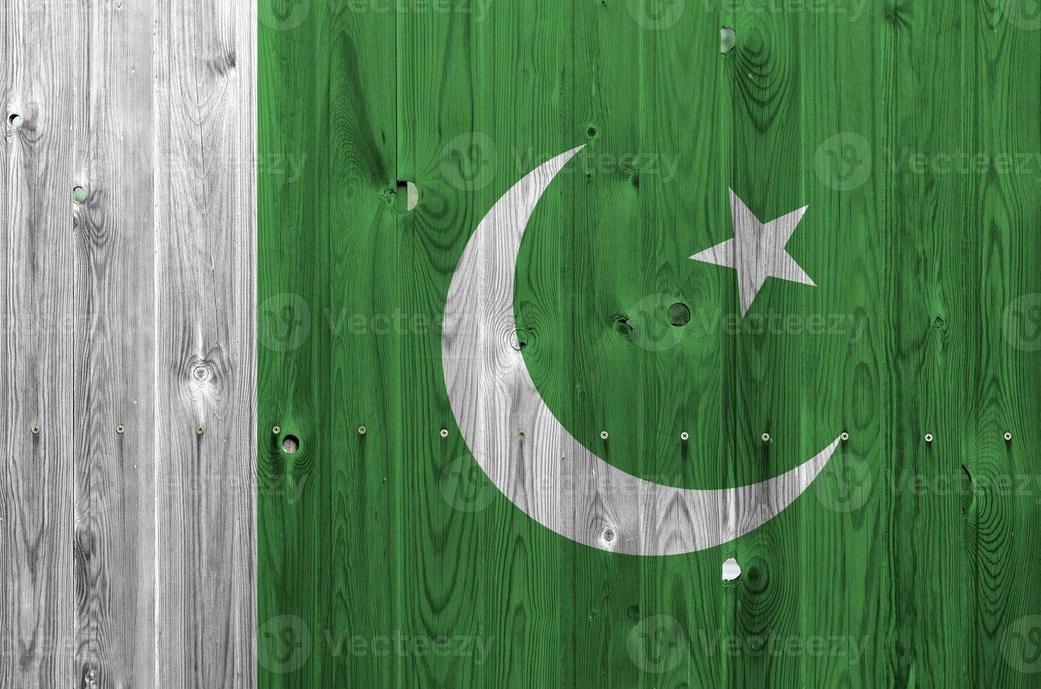Pakistan flag depicted in bright paint colors on old wooden wall. Textured banner on rough background photo