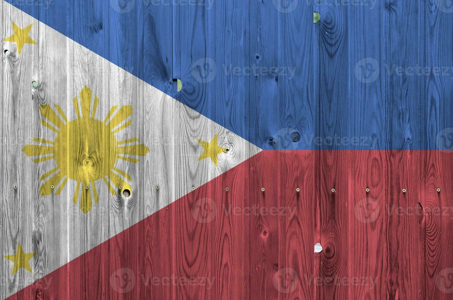 Philippines flag depicted in bright paint colors on old wooden wall. Textured banner on rough background photo