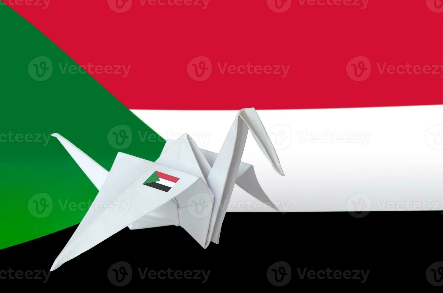 Sudan flag depicted on paper origami crane wing. Handmade arts concept photo