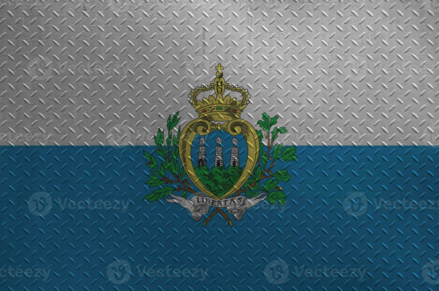 San Marino flag depicted in paint colors on old brushed metal plate or wall closeup. Textured banner on rough background photo