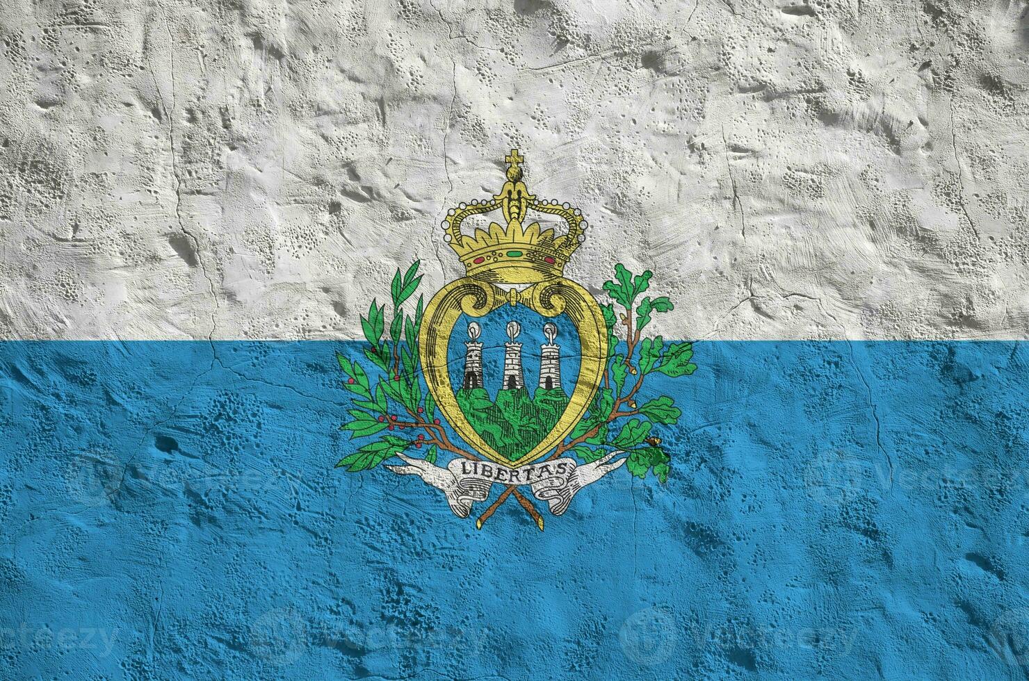 San Marino flag depicted in bright paint colors on old relief plastering wall. Textured banner on rough background photo