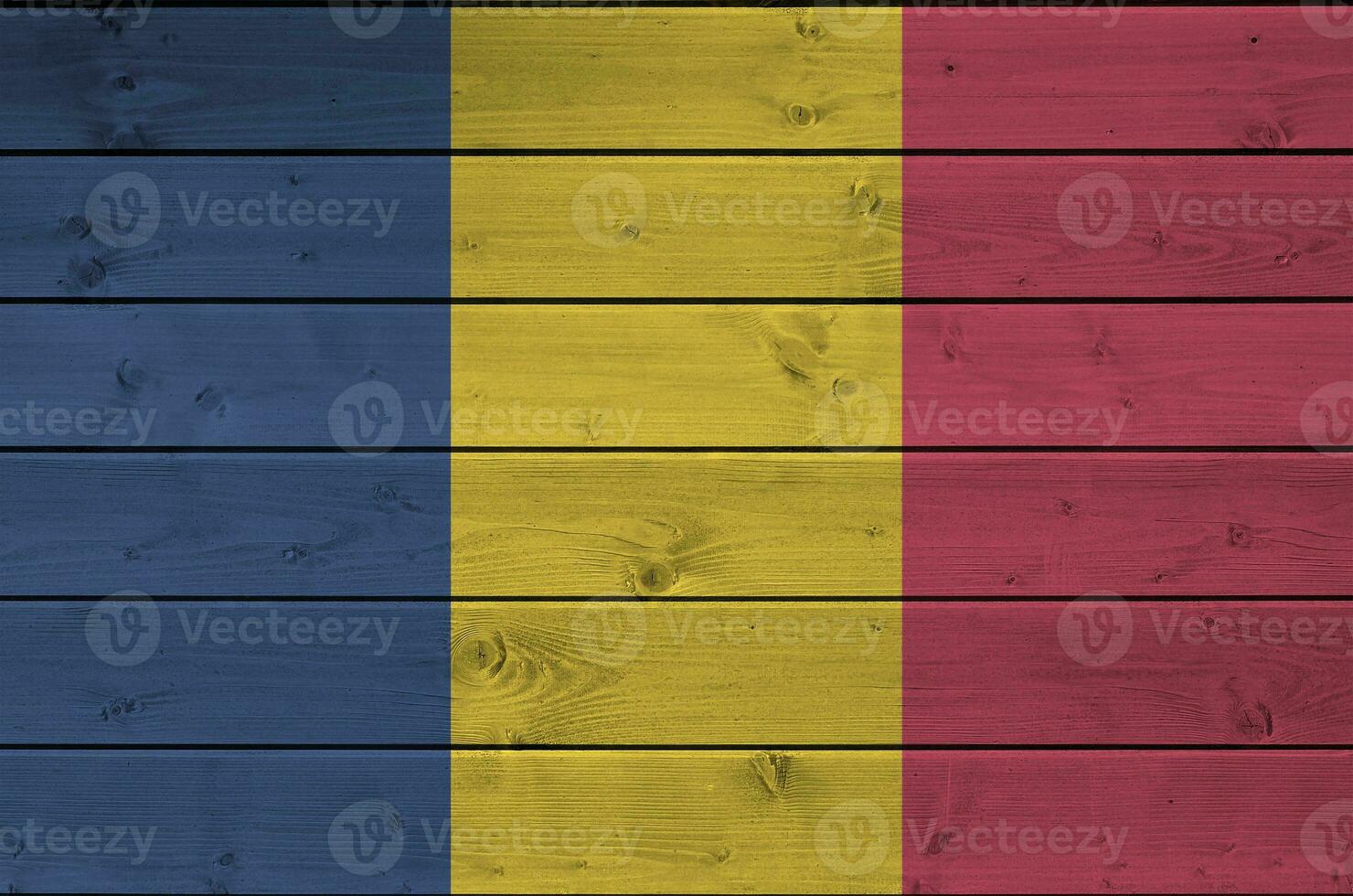 Chad flag depicted in bright paint colors on old wooden wall. Textured banner on rough background photo