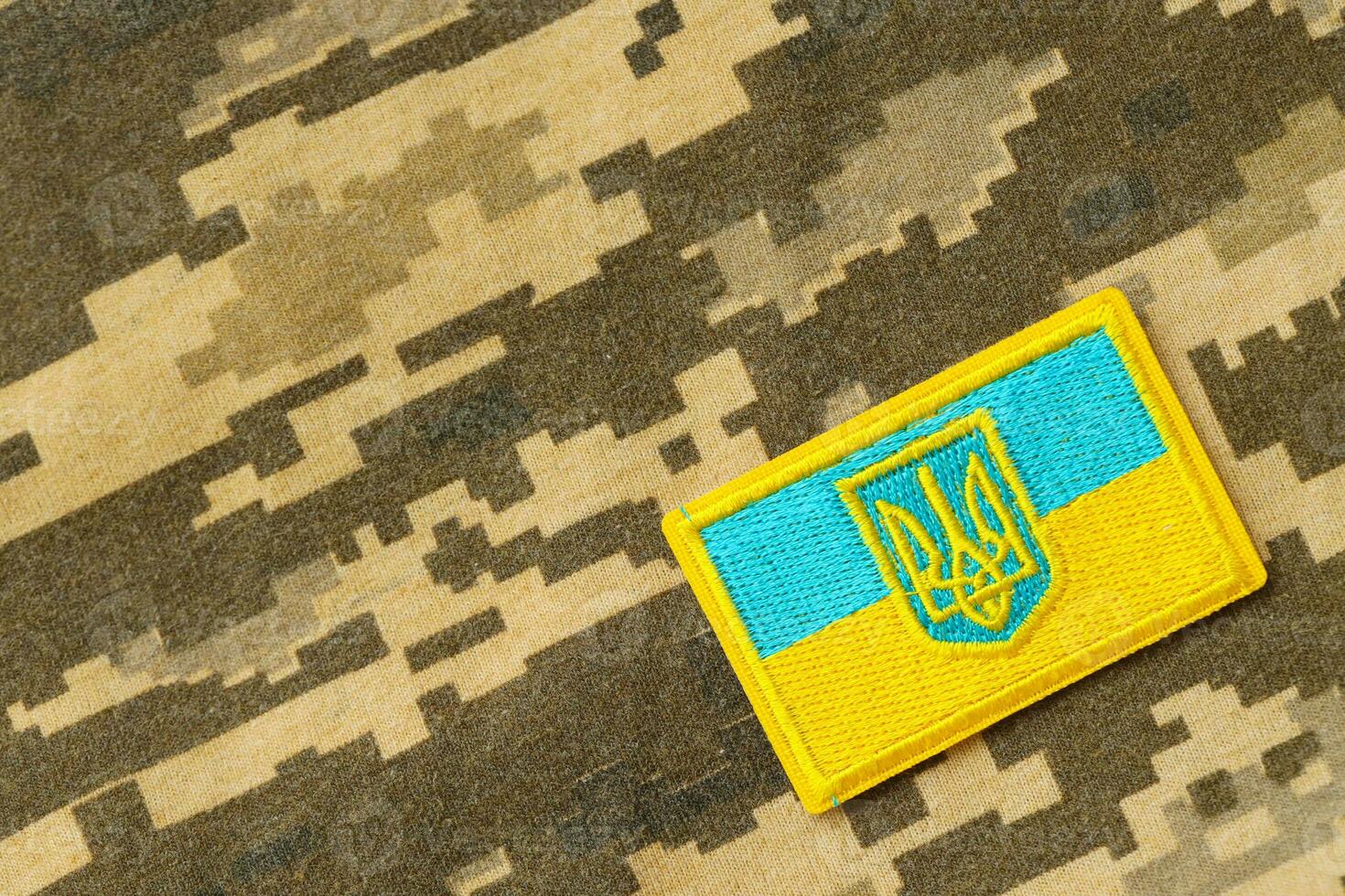 Military camouflage fabric with ukrainian flag on uniform chevron photo