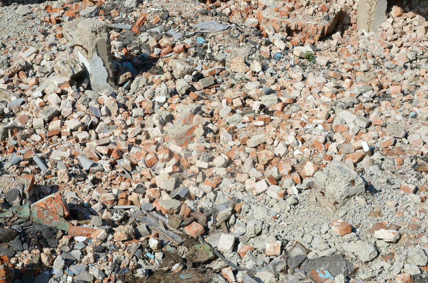 Pile of broken red bricks and fragments of concrete from destroyed building photo