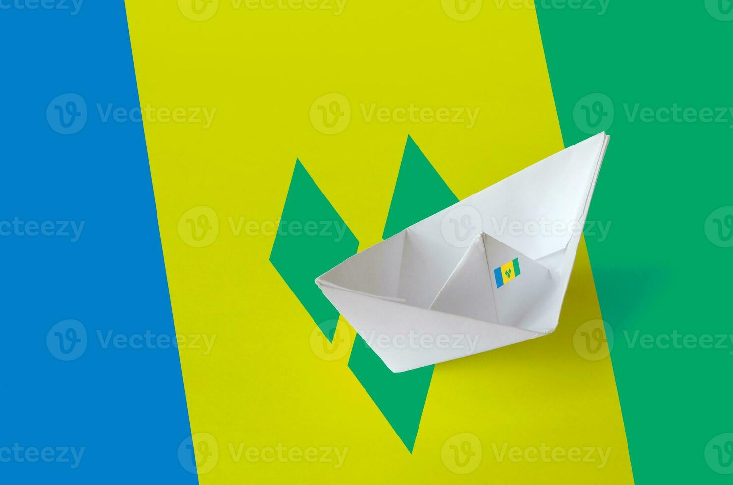 Saint Vincent and the Grenadines flag depicted on paper origami ship closeup. Handmade arts concept photo