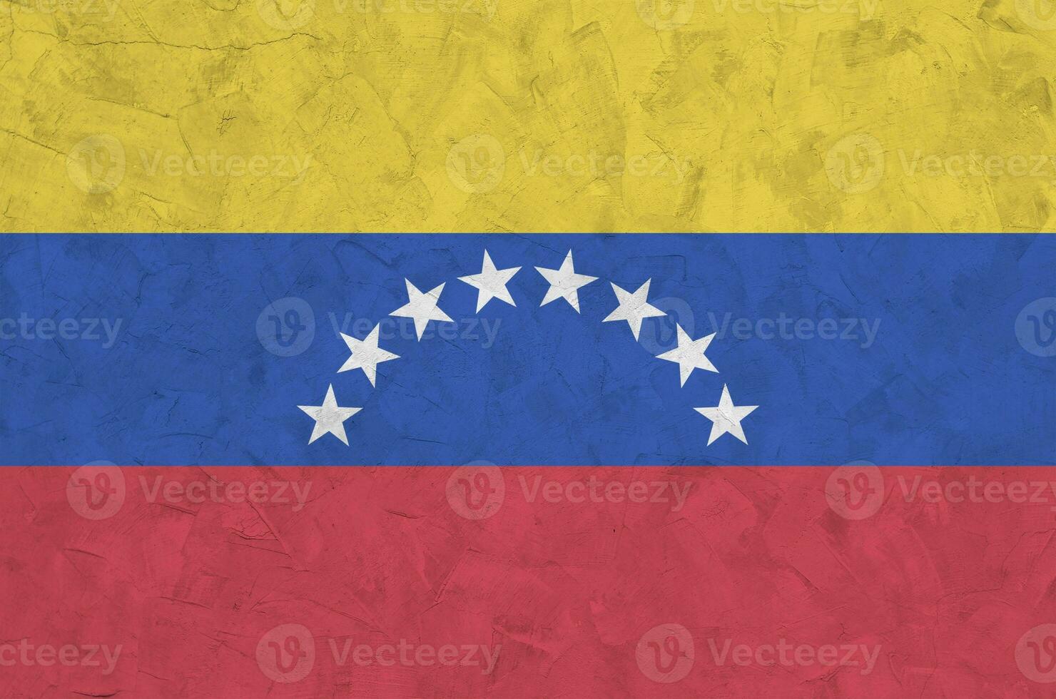 Venezuela flag depicted in bright paint colors on old relief plastering wall. Textured banner on rough background photo