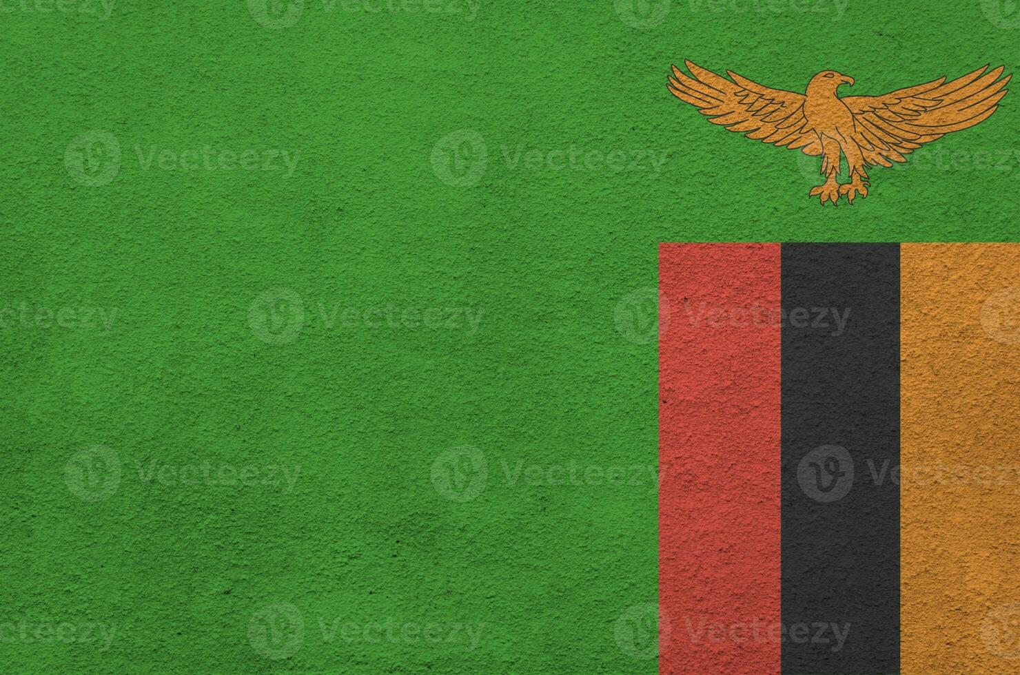Zambia flag depicted in bright paint colors on old relief plastering wall. Textured banner on rough background photo