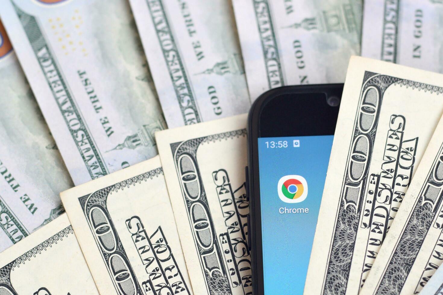 Smartphone screen with Google chrome app and lot of hundred dollar bills. Business and social networking concept photo