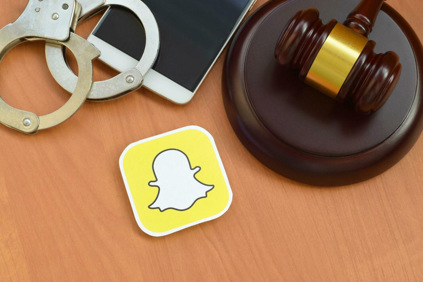 Judge Orders Premium Snapchat Model To Pay 60k Snapchat paper logo lies with wooden judge gavel, smartphone and