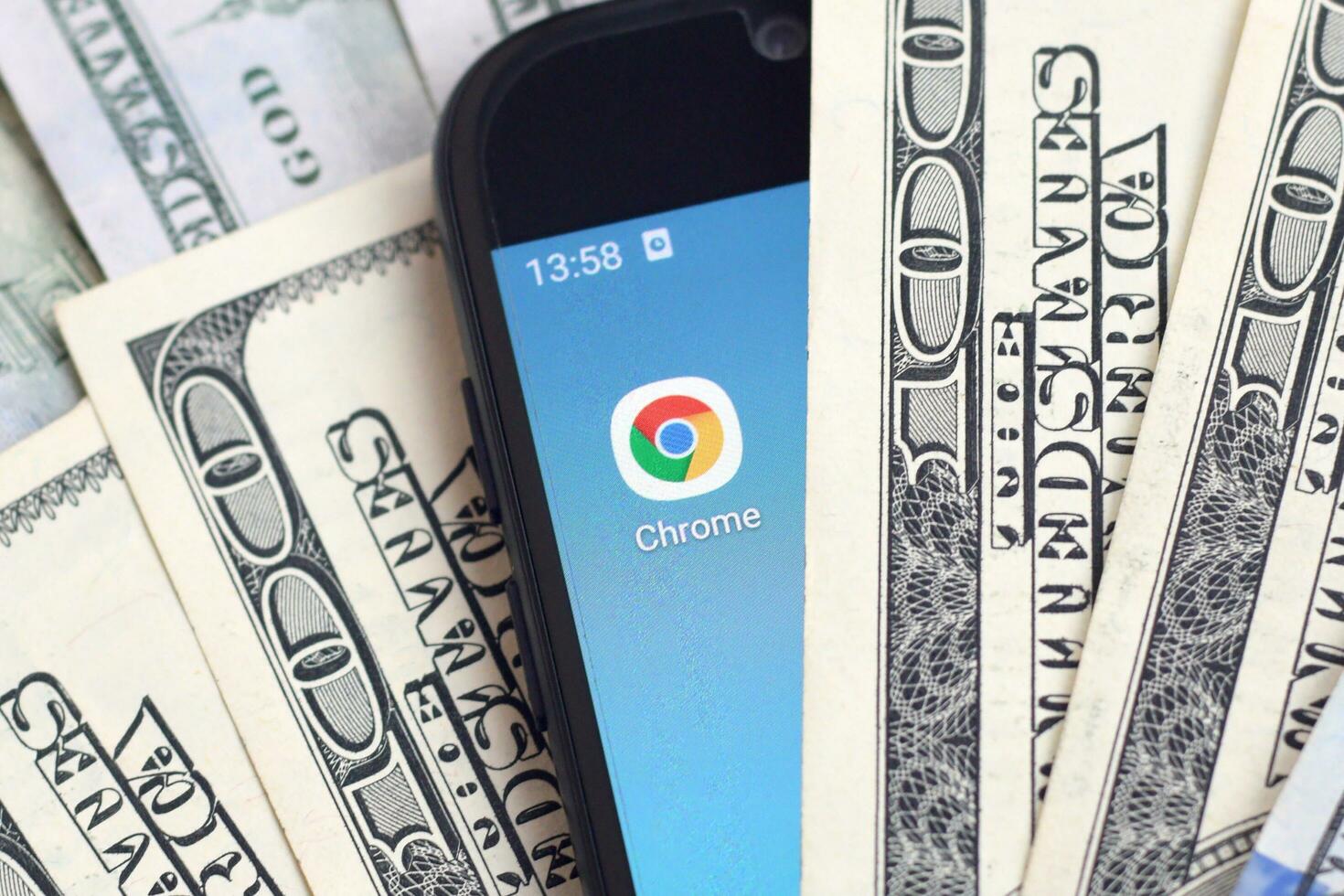 Smartphone screen with Google chrome app and lot of hundred dollar bills. Business and social networking concept photo