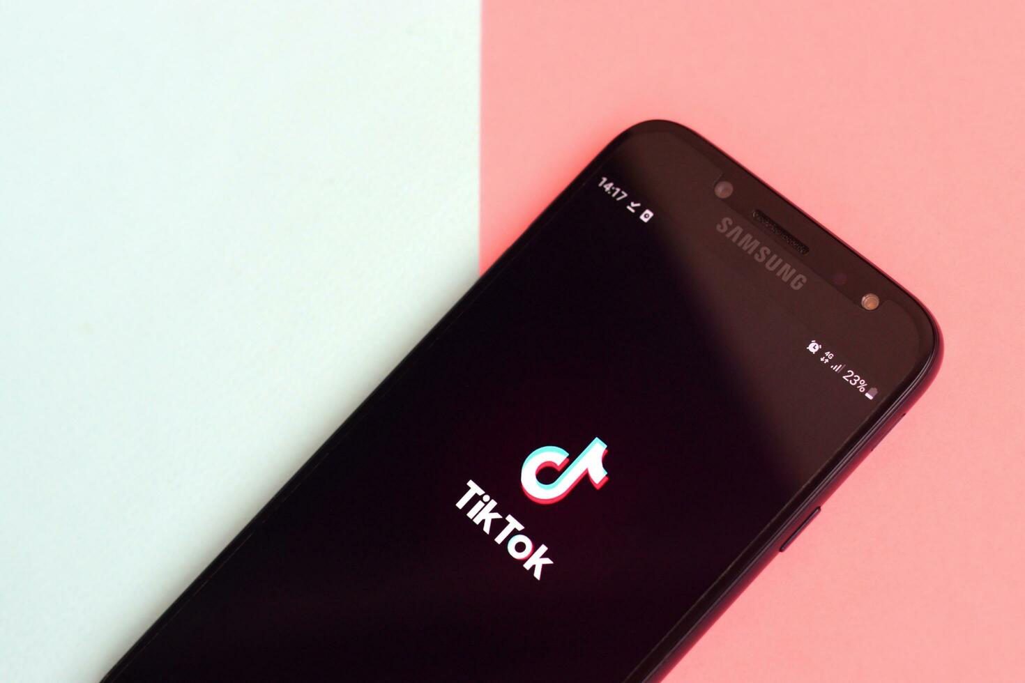Tiktok application on samsung smartphone screen on pastel background. TikTok is a popular video-sharing social networking service owned by ByteDance photo